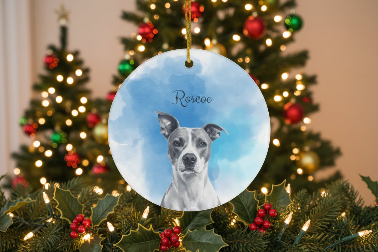 Round ceramic ornament with a dog's face on a blue sky background, hanging from a string.